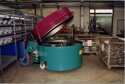 Cleaning machine as moveable top loader. Positioned close to the drawing press for the construction of seat consoles.