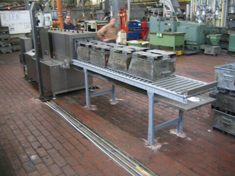 Durchlaufreinigungsanlage TW 106 mit Transportbehältern auf Rollenbahn im Umlauf